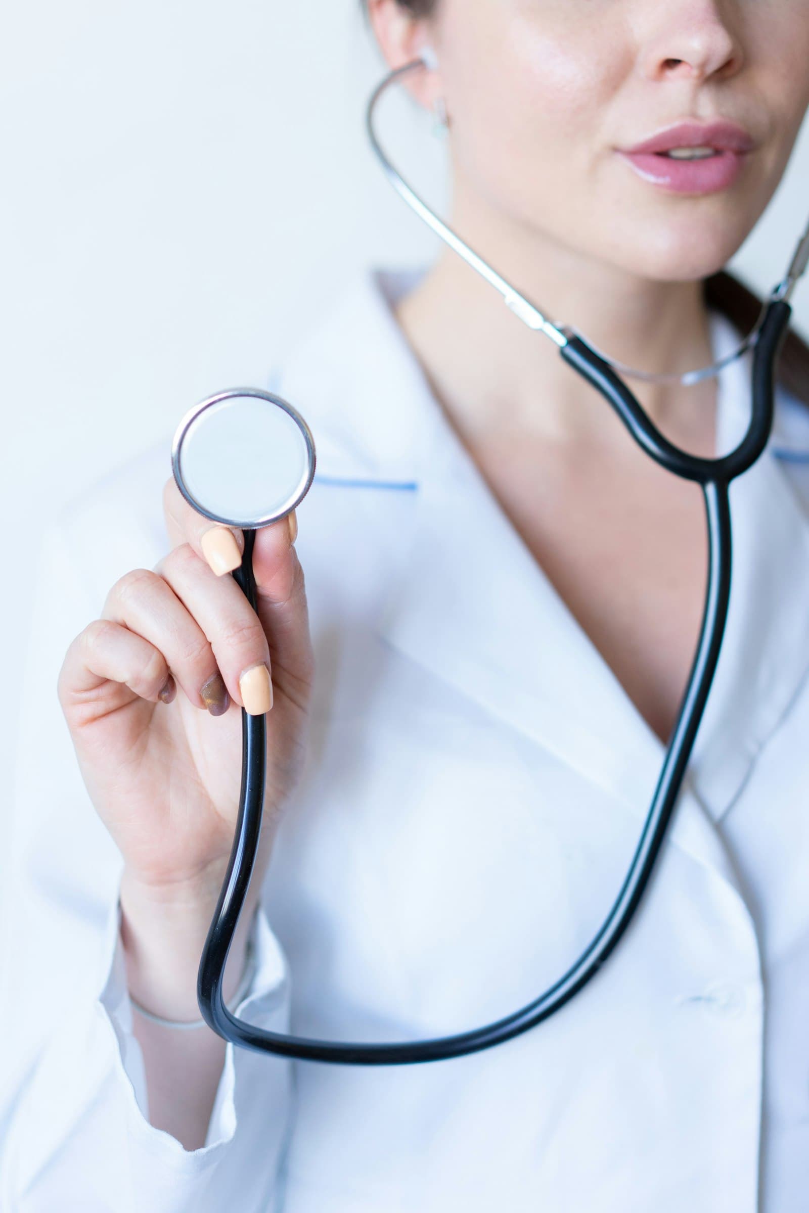 A clinician holding a stethoscope, editorial portrait