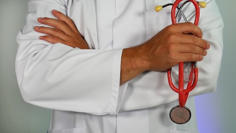 A doctor with arms crossed holding a stethoscope
